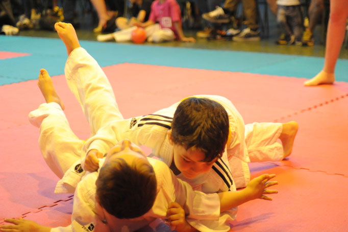 Niños realizando un ejercicio de judo en el suelo